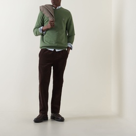 Model wearing Paul Smith Green Zebra Logo Crew Neck Sweatshirt, styled with dark brown trousers, light blue shirt, and tan bag.