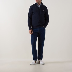 Model wearing Paul Smith Zebra Logo Half-Zip Sweatshirt in blue with dark jeans and white trainers.