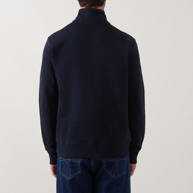Model wearing Paul Smith Zebra Logo Half-Zip Sweatshirt in blue, rear view, with stand collar and ribbed trims, styled with blue jeans.