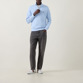 Model wearing Paul Smith Zebra Logo Half-Zip Sweatshirt in blue with grey trousers and white trainers.