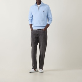 Model wearing Paul Smith Zebra Logo Half-Zip Sweatshirt in blue with grey jeans and white trainers.