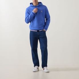 Model wearing Paul Smith blue cotton hoodie with kangaroo pocket, styled with dark indigo jeans and white trainers.