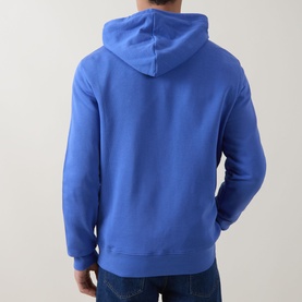 Model wearing Paul Smith blue cotton hoodie, rear view, styled with dark denim jeans