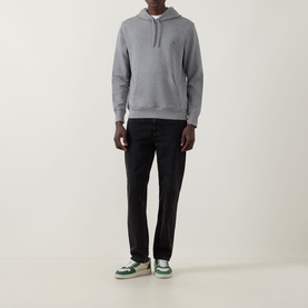 Model wearing Paul Smith Zebra Logo Drawstring Hoodie in grey with black jeans and green and white trainers.