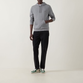 Model wearing Paul Smith Zebra Logo Drawstring Hoodie in grey with black trousers and green trainers.