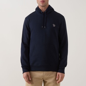 Model wearing Paul Smith Zebra Logo Hoodie in blue with drawstring hood and chest logo, styled with beige chinos.