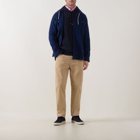 Model wearing Paul Smith Blue Zebra Logo Hoodie with navy jumper, pink shirt, tan chinos and navy trainers.