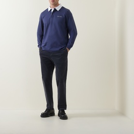 Model wearing Paul Smith blue cotton long-sleeve polo with white collar, styled with navy trousers and black leather shoes.