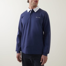 Model wearing Paul Smith blue cotton long-sleeve rugby polo shirt with white collar and embroidered logo, styled with dark trousers.