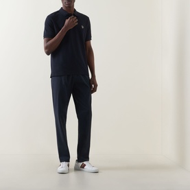 Model wearing Paul Smith Zebra Polo Shirt in blue with navy trousers and white trainers
