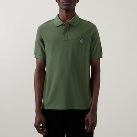 Model wearing Paul Smith green cotton polo shirt with zebra logo badge and three-button placket, short sleeves