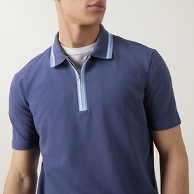 Model wearing Paul Smith blue cotton polo shirt with zip neckline and light blue contrast collar detailing, styled with white crew-neck tee