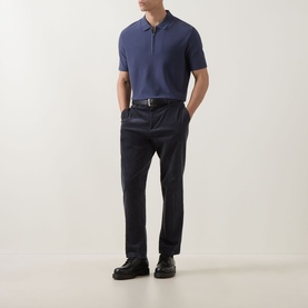 Model wearing Paul Smith Blue Polo in cotton-elastane blend, styled with dark navy trousers, leather belt and black loafers.