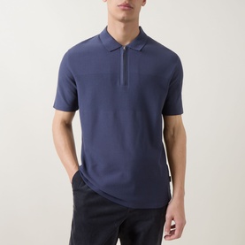 Model wearing Paul Smith blue cotton polo shirt with zip collar detail, styled with dark trousers
