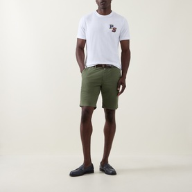 Model wearing Paul Smith Regular Fit Twill Chino Shorts in green with a white graphic tee and dark loafers.