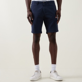 Model wearing Paul Smith Regular Fit Twill Chino Shorts in blue, styled with white socks and white leather trainers.