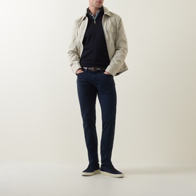 Model wearing Paul Smith Blue Slim Jeans, styled with a stone harrington jacket, navy polo shirt, and navy suede trainers.