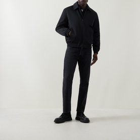 Model wearing Calvin Klein black casual jacket with collar, styled with matching dark trousers and black leather shoes.