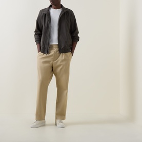 Model wearing Calvin Klein Beluga casual cotton jacket with white tee, khaki trousers and white trainers.