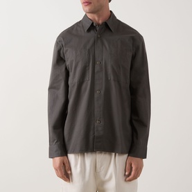 Model wearing Calvin Klein Garment Wash Twill Shirt in Beluga, long sleeves, front button placket, chest patch pockets, styled with cream trousers
