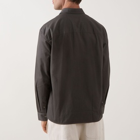 Model wearing Calvin Klein Garment Wash Twill Shirt in Beluga, dark grey cotton-linen, rear view, styled with light trousers