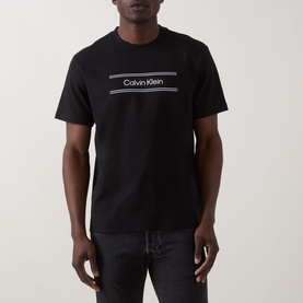 Model wearing Calvin Klein 20S SPW Graphic Logo T-Shirt in black with contrast chest logo print, crew neck, short sleeves, styled with dark jeans