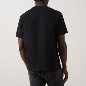 Model wearing Calvin Klein 20S SPW Graphic Logo T-Shirt in black, rear view, crew neck, short sleeves, paired with dark jeans.