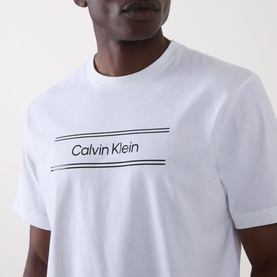 Model wearing Calvin Klein 20S SPW Graphic Logo T-Shirt in Bright White with contrast logo lettering across the chest, crew neckline
