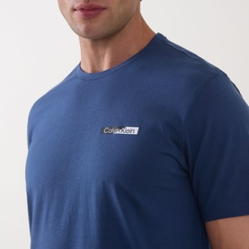 Model wearing Calvin Klein 30S Graphic Logo T-Shirt in Dark Denim, crew neck with small chest logo detail, short sleeves.