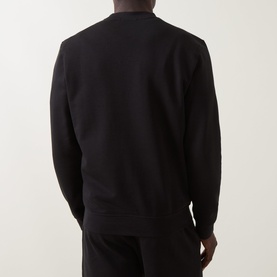 Model wearing Calvin Klein black cotton crew neck sweatshirt, back view, styled with matching black joggers.