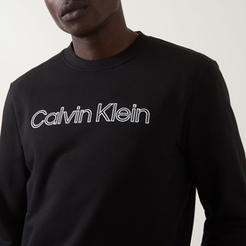 Model wearing Calvin Klein black cotton crew neck sweatshirt with white outlined logo print across chest