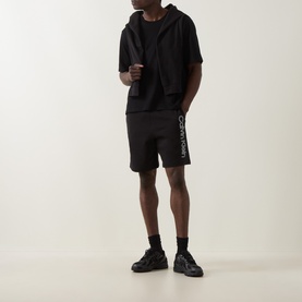 Model wearing Calvin Klein black cotton crew neck sweatshirt with matching black shorts and black chunky trainers