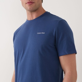 Model wearing Calvin Klein Micro Logo T-Shirt in Dark Denim, crew neck, short sleeves, small chest logo detail, 100% cotton smooth finish.
