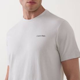 Model wearing Calvin Klein Micro Logo T-Shirt in Moonstruck, crew neck, short sleeves, small chest logo detail, smooth cotton finish.