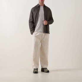 Model wearing Calvin Klein Micro Logo T-Shirt in Moonstruck, crew neck, styled with dark overshirt and cream wide-leg trousers.