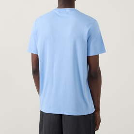 Model wearing Calvin Klein Monogram Logo T-Shirt in Placid Blue, crew neck, short sleeves, rear view, styled with dark trousers.