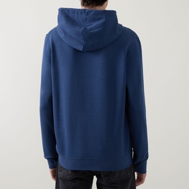 Model wearing Calvin Klein dark denim hoodie, back view, paired with dark jeans