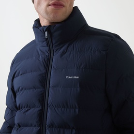 Model wearing Calvin Klein Logo Padded Jacket in Dark Sapphire, showing quilted funnel neck and two-way zip fastening with chest logo detail.