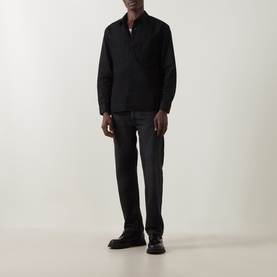 Model wearing black zip-neck overshirt with dark grey jeans and black leather shoes