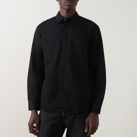 Model wearing black long-sleeve button-up shirt with chest pocket, styled with black jeans