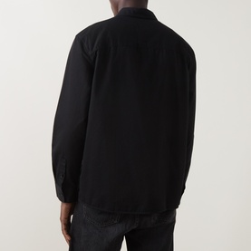 Model wearing black overshirt, rear view, relaxed fit with long sleeves and collar