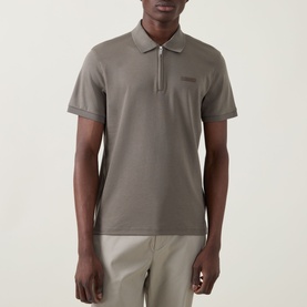 Model wearing Calvin Klein Supima Slim Zip Polo Shirt in Bungee Cord, featuring half-zip placket, short sleeves, and tonal logo badge.