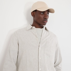 Model with Samsoe & Samsoe Addie Baseball Cap in Turtledove, curved brim, six-panel design, worn with a striped shirt.