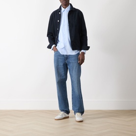 Model wearing Samsoe & Samsoe New Worker Denim Jacket in Salute, styled with light blue shirt and mid-wash jeans, white trainers.