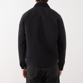 Model wearing Samsoe & Samsoe Robin Zip-Up Jacket in black, rear view, styled with dark denim jeans.