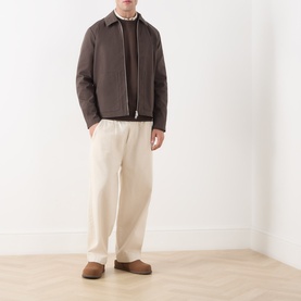 Model wearing Samsoe & Samsoe Paulo Zip Overshirt in Turkish Coffee with cream wide-leg trousers and tan suede slippers.