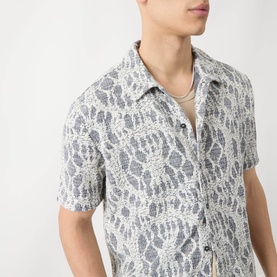 Model wearing Samsoe & Samsoe Casual Shirt in Salute Symmetry, short-sleeve camp collar with abstract lace-effect print, styled with a layered
