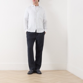 Model wearing Samsoe & Samsoe Ryan Striped Shirt in Clear Blue St., styled with dark trousers and black shoes.