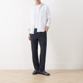 Model wearing Samsoe & Samsoe Ryan Striped Shirt in Clear Blue St., styled with navy trousers and dark loafers, full-length view.