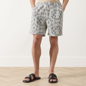 Model wearing Samsoe & Samsoe Salute Symmetry shorts with elasticated waist and geometric print, styled with black leather sandals.
